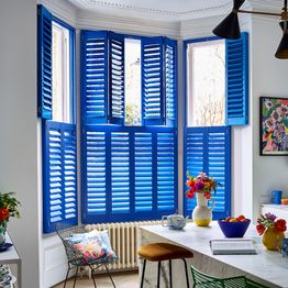 richmond deep blue tier on tier shutters on a bay window in a kitchen