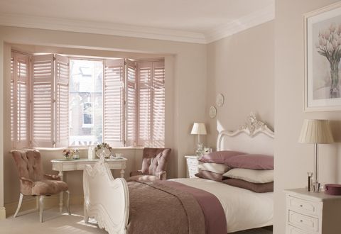 Taupe full height shutters in bedroom with classic furnishings