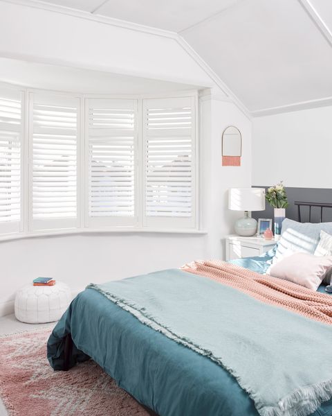 craftwood full height white shutters on a curved bay window in a bedroom