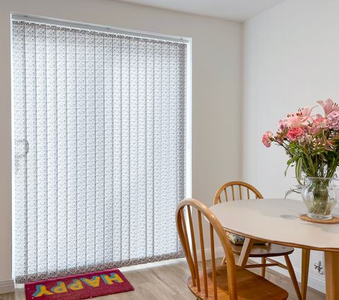 harriet ocean depths patterned vertical blinds on sliding patio doors in dining room with wooden furniture
