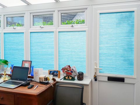 teal pleated blinds on conservatory side windows in office