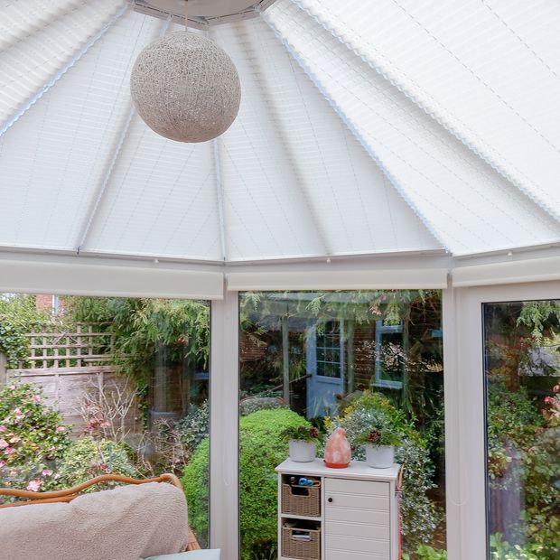 plain white pleated blinds fitted to circular conservatory roof