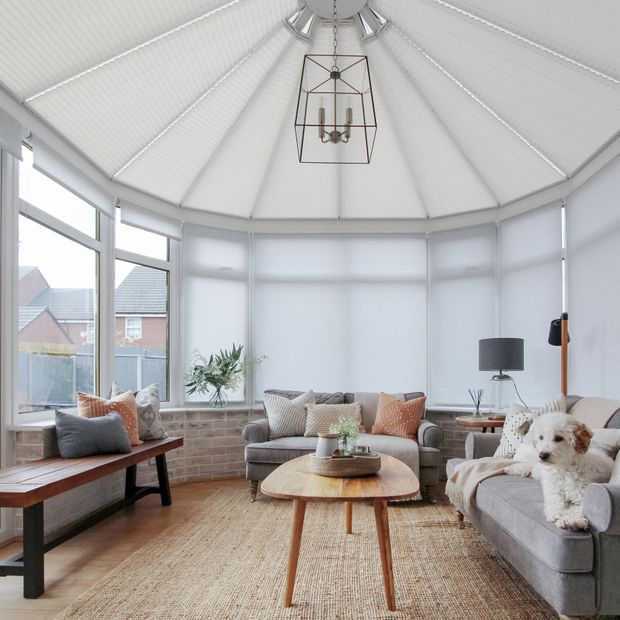 side conservatory roller blinds paired with white pleated roof blinds in large circular conservatory