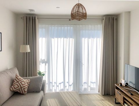 light grey floor length curtains paired with white voile curtains in greige themed living room