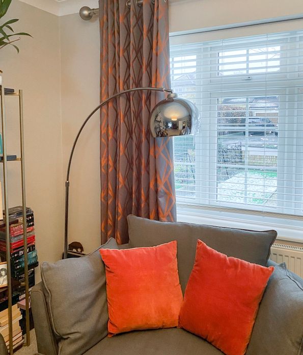 grey and orange geometric print curtains on living room windows