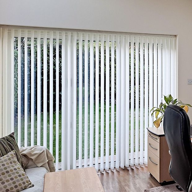 white floor length vertical blinds covering large patio doors in office conservatory