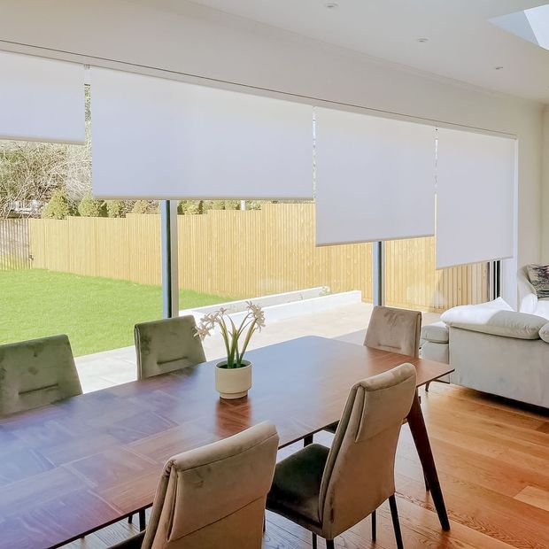Acacia white roller blinds on large sliding patio doors in dining/living area