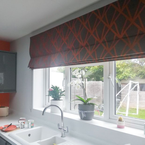 orange and grey geometric print roman blinds on kitchen window above sink