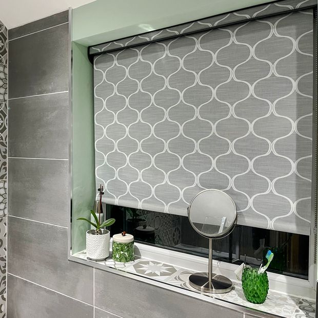 grey patterned roller blind in bathroom with grey walls and silver furnishings