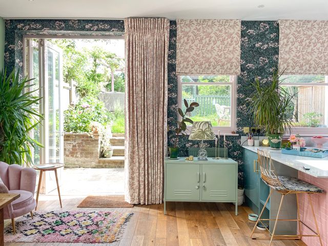 pink floral roman blind and curtain in kitchen/living area with floral patterned walls and furnishings