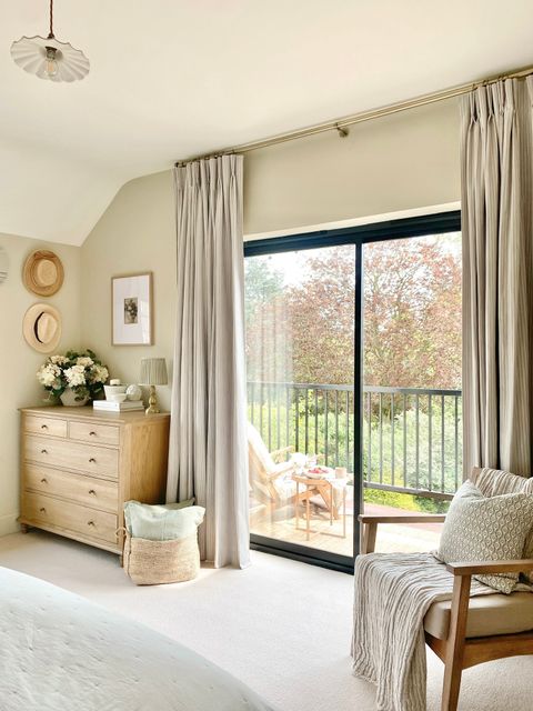 cream floor length curtains on wide bedroom patio doors leading out to balcony