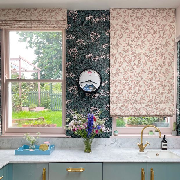 pink floral roman blind and curtain in kitchen/living area with floral patterned walls and furnishings