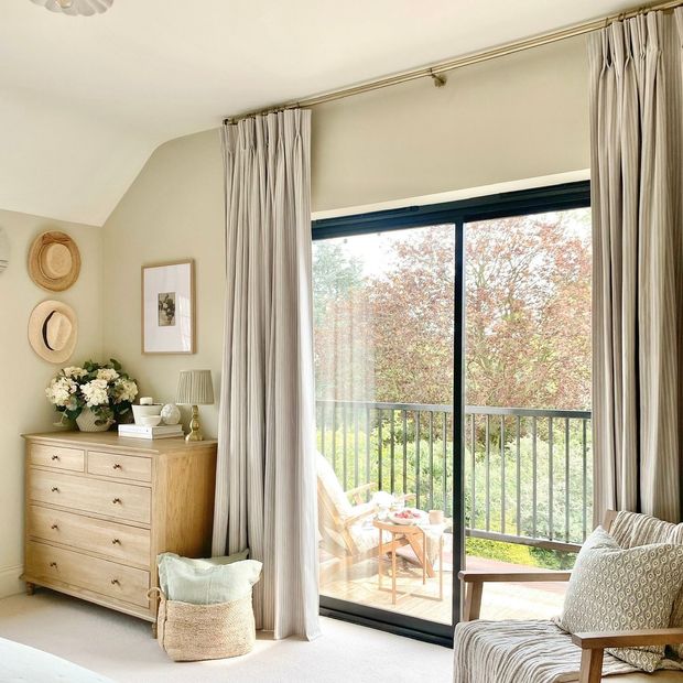 floor length cream striped curtains on large sliding patio doors leading out to balcony in bedroom