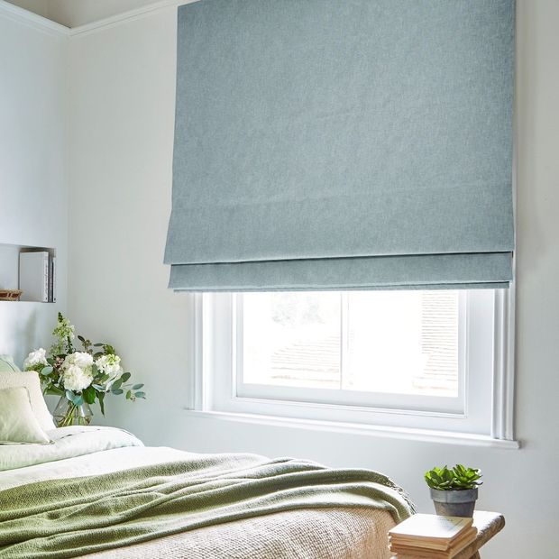 textured plain light blue roman blinds in bedroom with spring green bedding