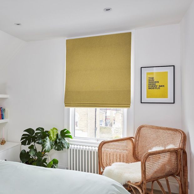 bright yellow plain roman blinds on small window in bedroom