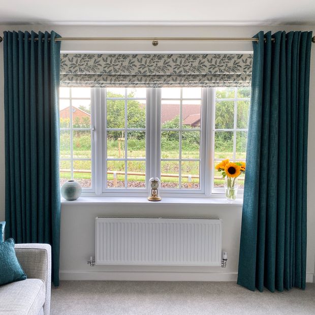 Delizia teal green Roman blinds paired with boheme teal curtains in living room