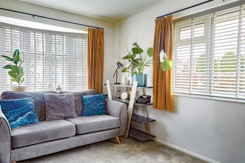 faux wood fine white venetian blinds on two windows in small living room