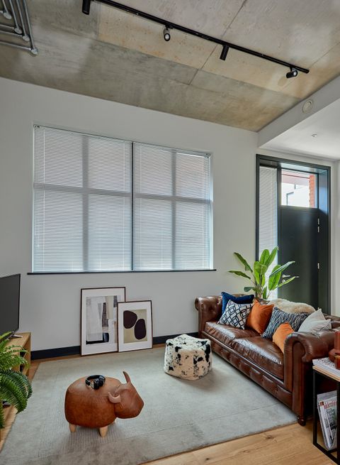 metal venetian blinds on large window in industrial themed living room