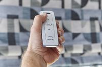 close up of somfy remote used to control motorised blinds in the background