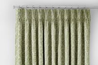 close up of green patterned curtain with leaves on