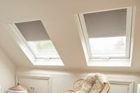 light grey roller blinds on two skylight windows in attic bedroom