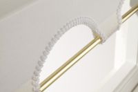 gold pole going through the bottom of a shaped roller blind hem