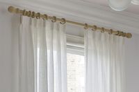 white voile curtains on light wooden pole in bedroom