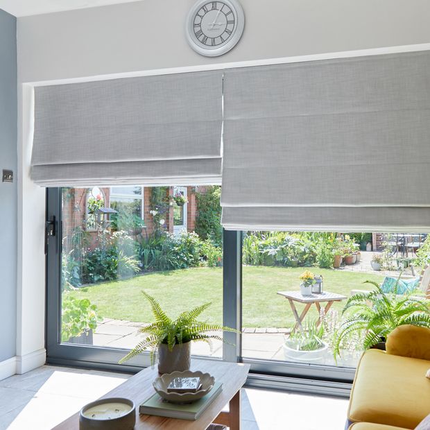 pair of silver roman blinds on large sliding patio doors in living room