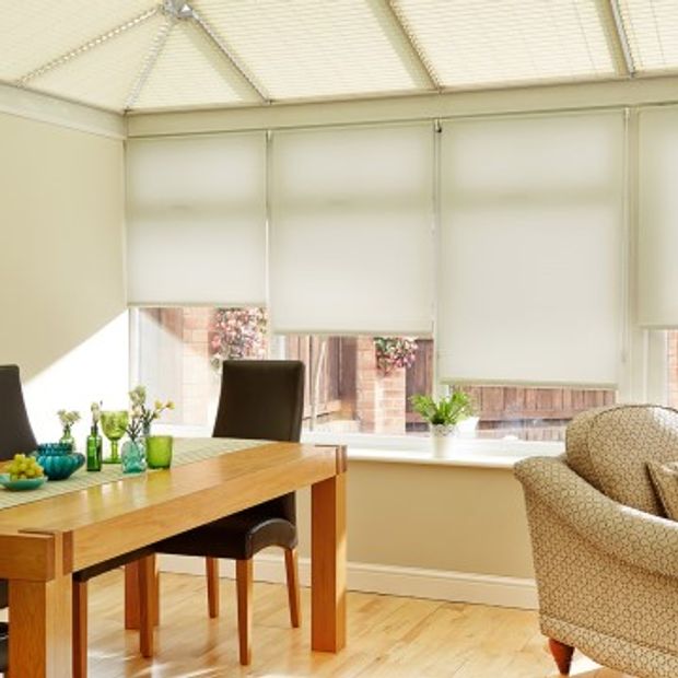 Plain white Cordova White roller blinds hung in conservatory