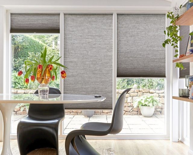 grey duette pleated honeycomb blinds on patio window in living/dining space