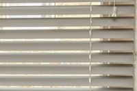 close up of grey metal venetian blinds on kitchen window