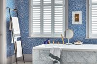silk white shutters on bathroom windows with blue walls