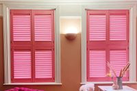 bright pink tier on tier shutters on windows in living room