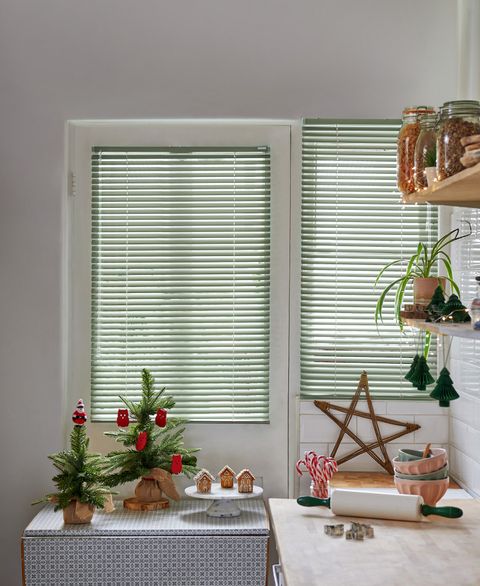 green venetian blinds on kitchen windows with christmas decorations
