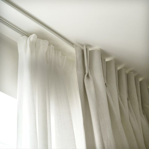 close up of cream curtains paired with white voiles on a double track