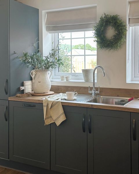 silver roman blinds on windows above kitchen sink