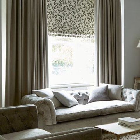 Living room with furniture and one large window with Aurella Ash roman blinds and Harlow Charcoal curtains