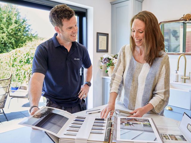 Hillarys Advisor showing a happy customer the options available to her in her scheduled private in home appointment