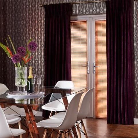 Dining room with glass table and glass door perfectly fitted with Gold Copper venetian blinds and Made To Measure Lyon Plum curtains