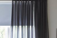 Black coloured voile curtain matched with a blue roller blind
