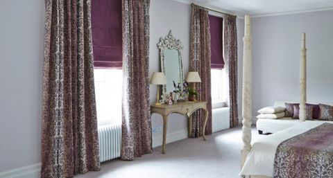 Patterned Curtains with Purple Roman blinds in guest bedroom